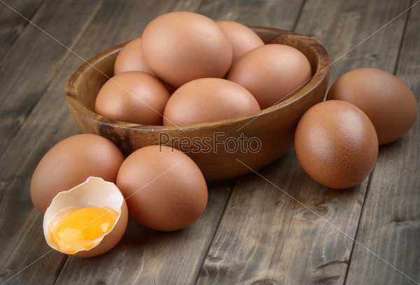 eggs in a wooden bowl on the table from the old boards broken  egg shell and yolk