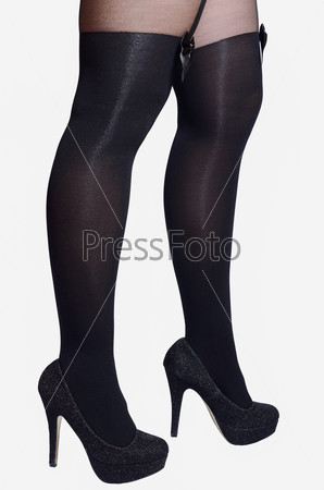 Beautiful sexy female legs in black tights with a bow on a white background