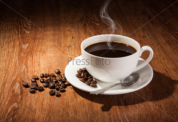 Still-life with a cup of black coffee and roasted coffee beans close up