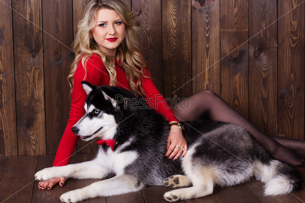 Young girl wearing red dress with her husky dog