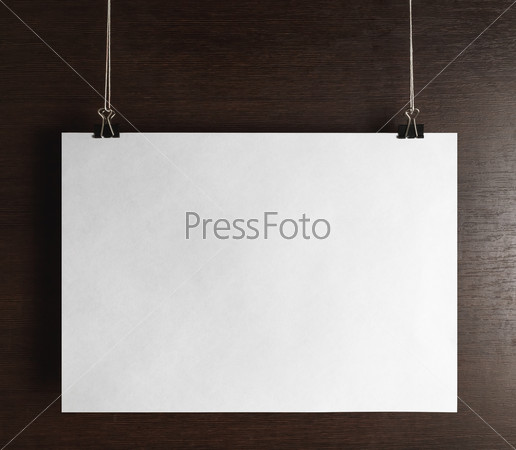 Blank poster hanging on wooden background. Front view, stock photo