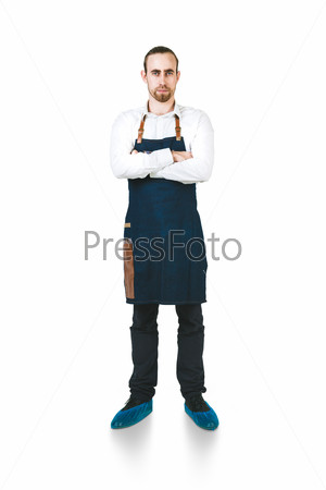 A shoot of young caucasian men in apron as a barmen. Crossing hands on the chest.  Isolated against white background.