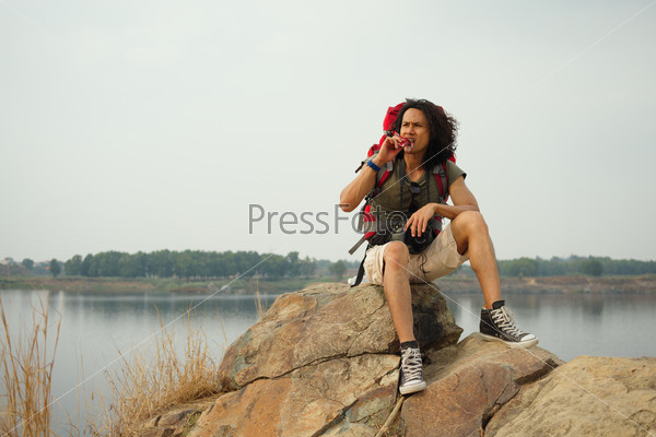 Hiker sitting on mountain and eating a chocolate bar