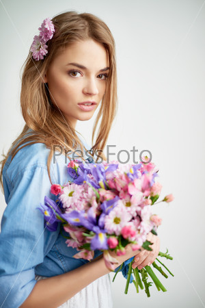 Pretty young lady with flowers looking at camera