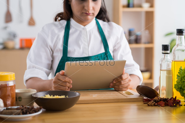 Cropped image of Indian housewife reading a recipe on the digital tablet