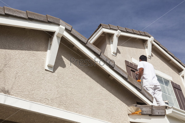 Busy House Painter Painting the Trim And Shutters of A Home, stock photo