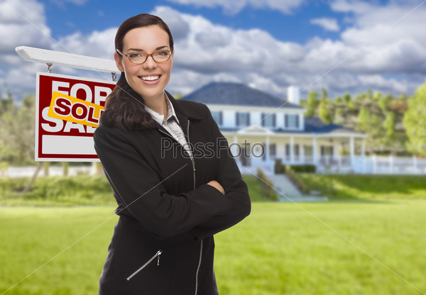 Attractive Mixed Race Woman in Front of House and Sold Real Estate Sign.