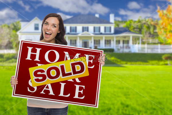 Excited Mixed Race Female with Sold Home For Sale Real Estate Sign In Front of Beautiful House.