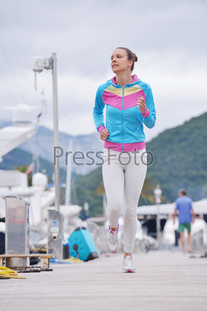 woman jogging at early morning with yacht boats in marina