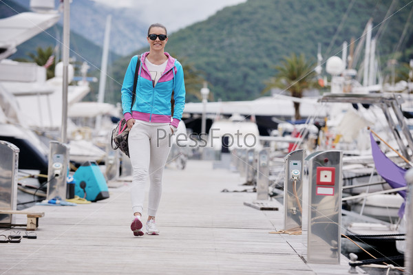 relaxed young woman walking in marina