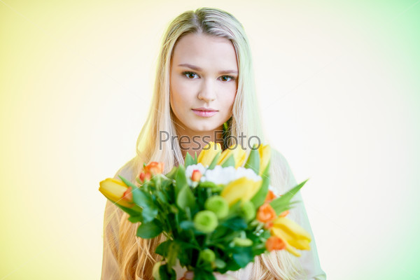 Serious blond girl holding floral bouquet