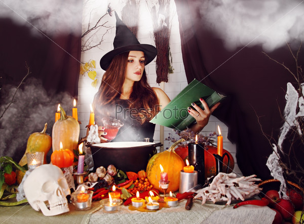 Beautiful Witch brew the potion in the boiler, stock photo
