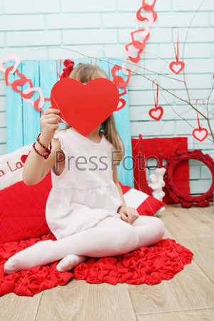 Little girl in the festive decor for Valentine\'s Day