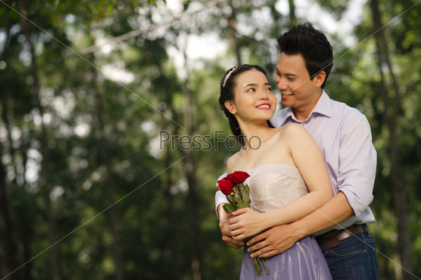 Happy Vietnamese man embracing his lovely sweetheart