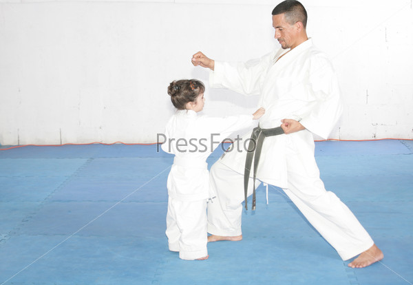 Teacher training karate to a little girl