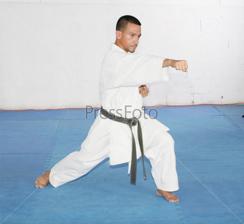 Black belt Man in kimono during training karate kata exercises in gym