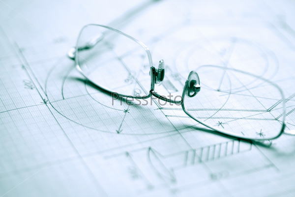 Closeup of spectacles on graph paper with industrial design