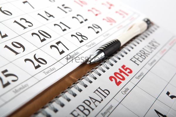 wall calendars with pen laid on the table close up