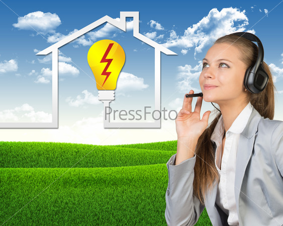 Businesswoman in headset, her hand on microphone, smiling. Symbol of electrical supply and service beside. Green hills and blue sky as backdrop