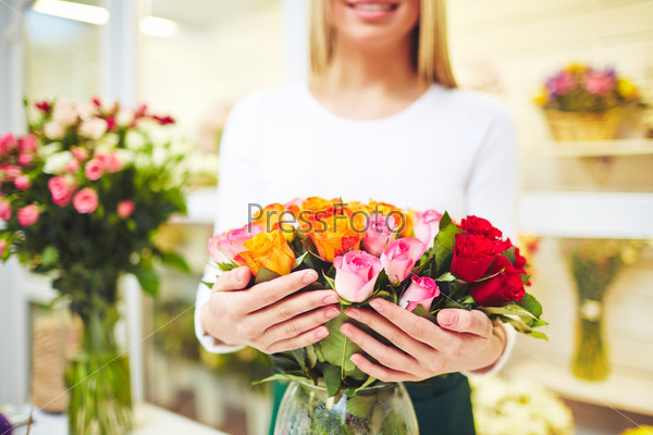 Female florist holding fresh roses of various colors