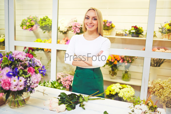 Friendly seller of fresh flowers looking at camera, stock photo