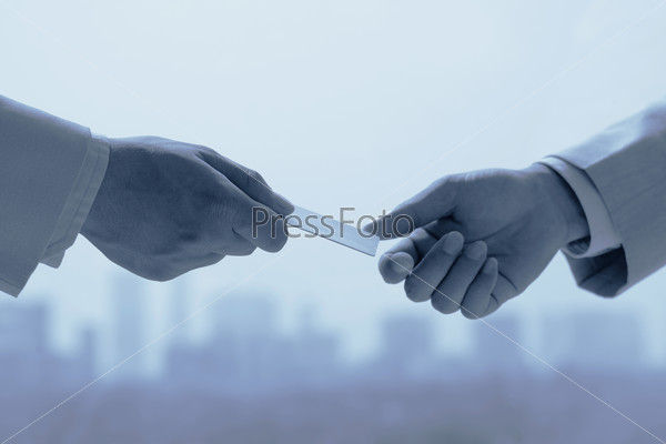 Close-up of business partners exchanging business card