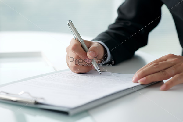 Businessman signing legal document, selective focus