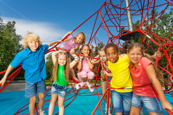 Group of children stand on red ropes and play