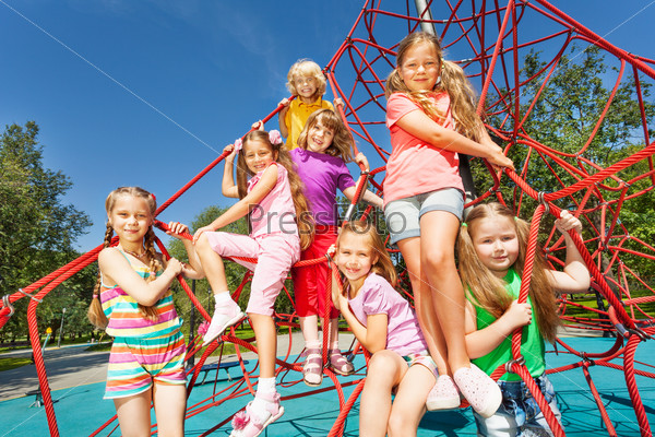 Smiling group of children sit on red ropes