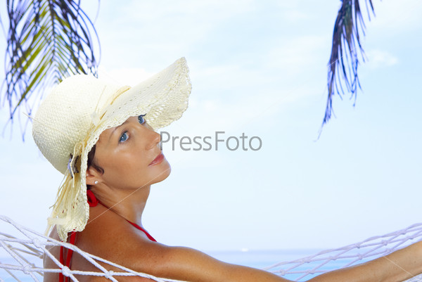 view of nice woman lounging in hammock in tropical environment