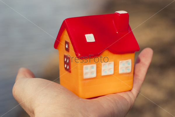 Игрушечный домик в руке