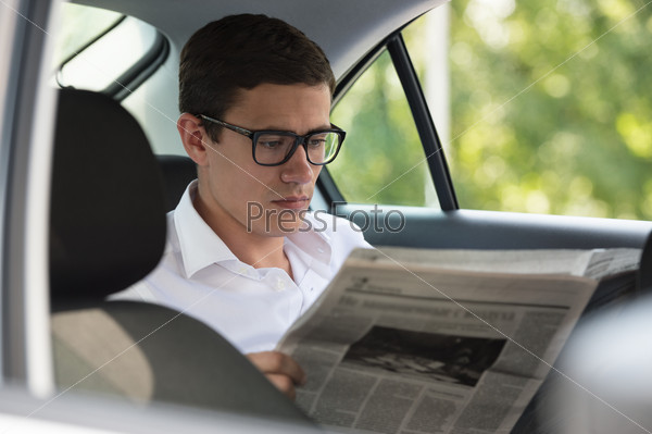 Businessman reading news in his car