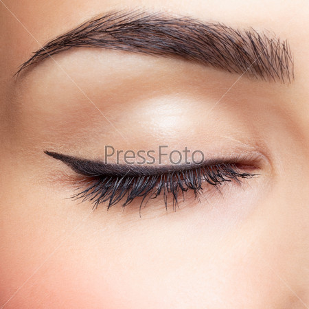 close-up portrait of young beautiful woman\'s closed, eye zone make up with black arrow