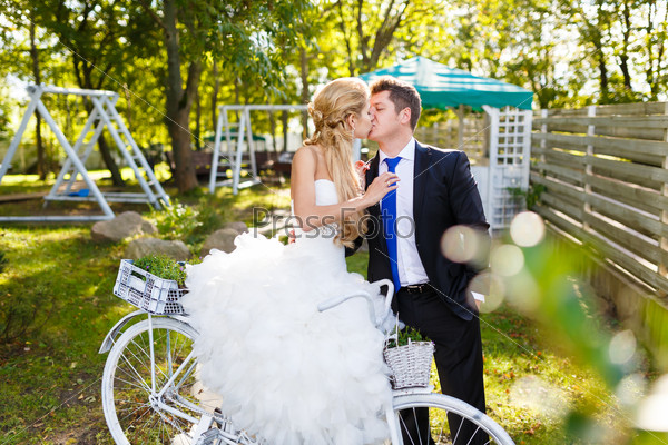 Pretty young newlyweds with bike