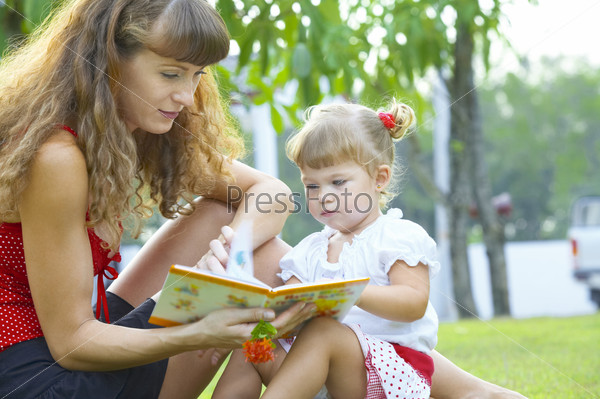portrait  of young mother and baby getting busy with the book