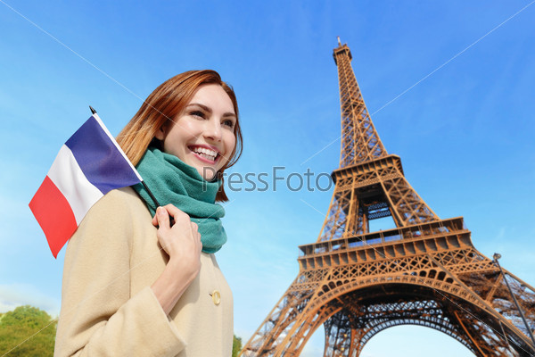 Happy woman travel in Paris with eiffel tower and beautiful blue sky and holding France French flag, caucasian beauty