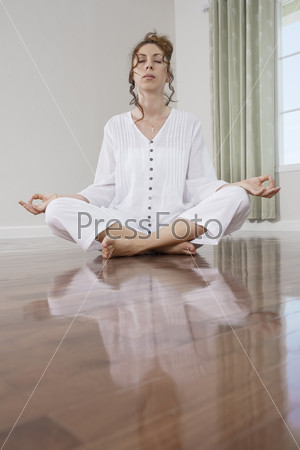 portrait of young meditating woman in domestic environment