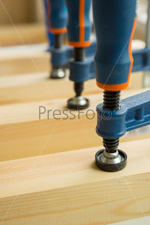 Wood pasting by clamps in a joiner\'s workshop