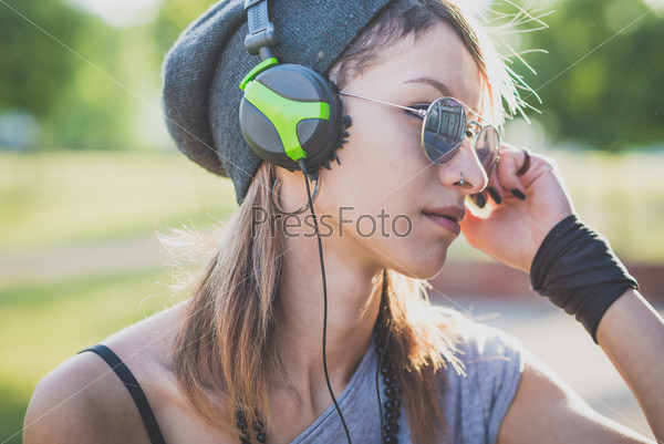 young beautiful model woman listening music in the city