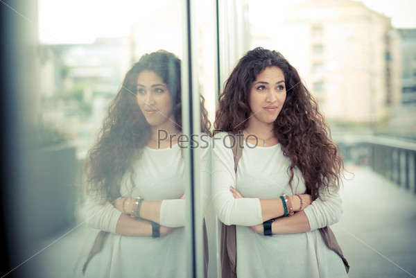 Beautiful curly long brunette hair moroccan woman in the city, stock photo
