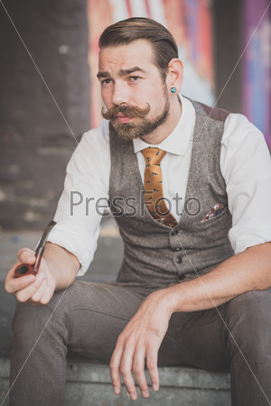 handsome big moustache hipster man smoking pipe in the city