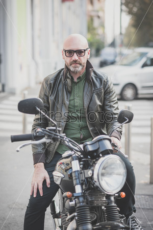handsome middle aged man motorcyclist in the city
