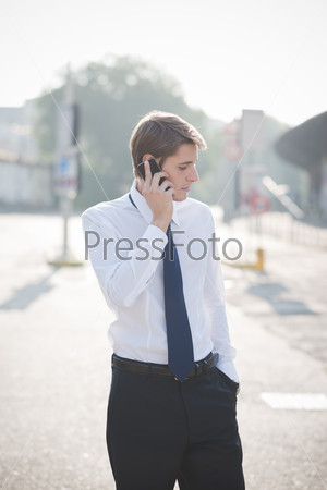 young handsome elegant blonde model man using smart phone in the city
