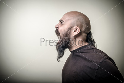Profile screaming angry bearded man on gray background, stock photo