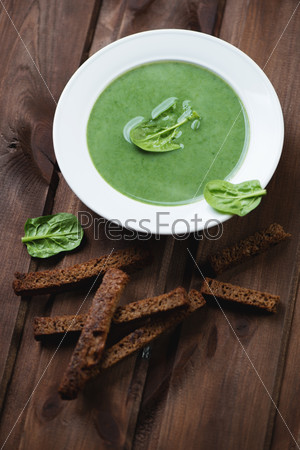 Spinach soup with croutons, studio shot, selective focus