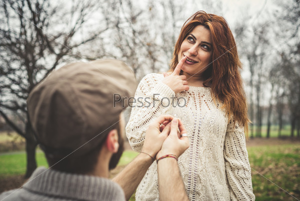 couple in love marriage proposal at the park winter