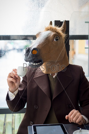 young stylish man lifestyle horse mask at the bar in the city