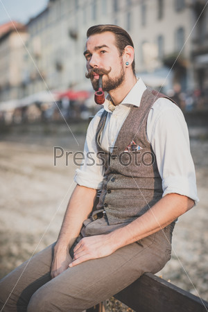 handsome big moustache hipster man smoking pipe  in the city