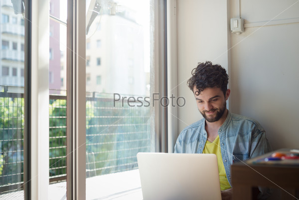 Handsome hipster modern man designer working home using laptop at home, stock photo