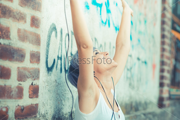 Young beautiful short blue hair hipster woman with headphones music in the city, stock photo